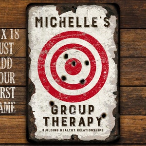 May include: A white metal sign with a red and white target in the center. The sign says "Michelle's Group Therapy Building Healthy Relationships".