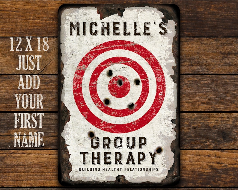 May include: A white metal sign with a red and white target in the center. The sign says "Michelle's Group Therapy Building Healthy Relationships".