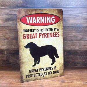 Puede incluir: Un cartel de advertencia con un aspecto desgastado y vintage. Dice "WARNING PROPERTY IS PROTECTED BY A GREAT PYRENEES GREAT PYRENEES IS PROTECTED BY MY GUN". El cartel presenta una silueta de un perro de monta&ntilde;a de los Pirineos.