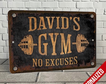 Peut inclure: Une plaque en métal rustique avec un fond noir et des lettres dorées. La plaque indique "David's Gym No Excuses" avec une barre et des poids de chaque côté du mot "Gym".