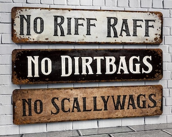 May include: Three rustic metal signs with a distressed look. The top sign is white with black text that reads "NO RIFF RAFF". The middle sign is black with white text that reads "NO DIRTBAGS". The bottom sign is brown with black text that reads "NO SCALLYWAGS".