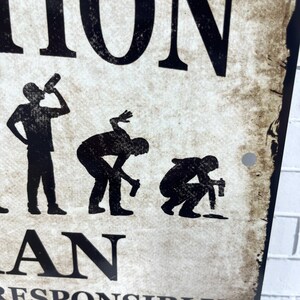 Op de afbeelding: Een zwart-wit bord met de tekst "Evolution of a Man" en een reeks silhouetten die een man in verschillende stadia van dronkenschap voorstellen.