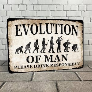 Op de afbeelding: Een bruin metalen bord met de tekst "Evolution of Man" en een reeks stokfiguren die de evolutie van de mens voorstellen. Het bord bevat ook de tekst "Please Drink Responsibly".