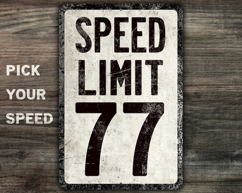 May include: White metal sign with black text that reads "Speed Limit 77". The sign has a distressed, vintage look.