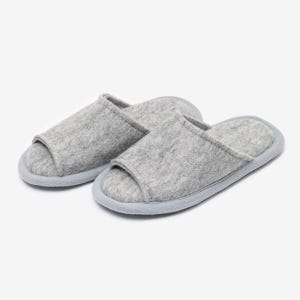 Peut inclure: Une paire de pantoufles en feutre gris avec un design &agrave; bout ouvert. Les pantoufles ont une semelle gris clair.