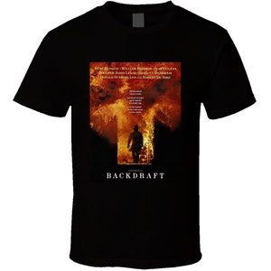 Peut inclure: T-shirt noir avec l'affiche du film "Backdraft". L'affiche montre un pompier devant des flammes. Le titre du film est en bas, et les noms des acteurs sont en haut de l'affiche.