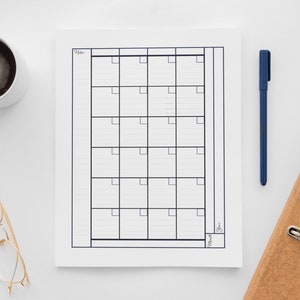 Peut inclure: Un calendrier imprimable noir et blanc avec une grille de 30 cases. Le calendrier comporte le mot "Mois" en bas et "Année" à droite. Le calendrier est sur une surface blanche avec une tasse de café, une paire de lunettes, un stylo et un classeur.