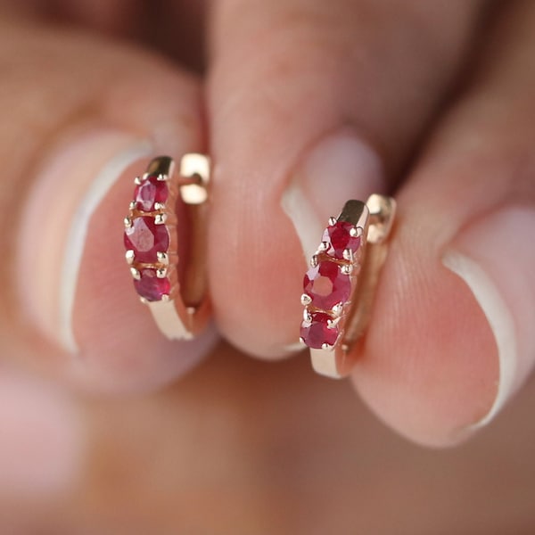 Boucles d'oreilles créoles Huggie en or jaune 14 carats massif, serties de 3 rubis véritables. Bijoux fins ornés de 3 pierres précieuses.