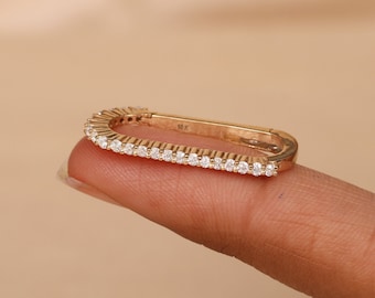 May include: A gold-toned, rectangular-shaped earring with a row of small, clear cubic zirconia stones around the perimeter. The earring is marked "18K" on the back.