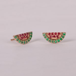 Puede incluir: Un par de pendientes de oro en forma de sandía con piedras preciosas rojas y verdes.