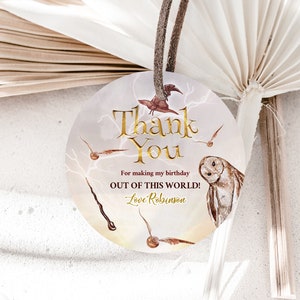 May include: Round thank you tag with a brown owl, lightning bolts, and gold lettering. The text reads "Thank You for making my birthday OUT OF THIS WORLD! Love, Robinson."