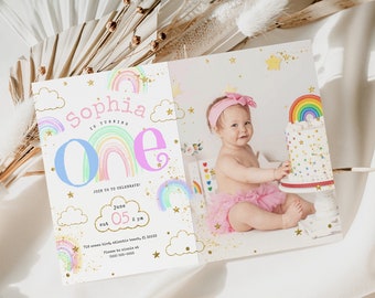 May include: A rainbow-themed first birthday invitation with a photo of a baby girl holding a cake. The invitation features a colorful rainbow, stars, and clouds. The text on the invitation reads "Sophia is turning one" and includes the date and time of the party.