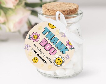 May include: A round thank you favor tag with a pink, blue, and yellow color scheme. The tag features a smiling face, flowers, and butterflies. The text reads "Thank You" in a retro font and "For making my birthday special. Love, Elizabeth."