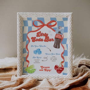 May include: A framed sign with a retro design for a "Dirty Soda Bar." The sign features a Coca-Cola bottle illustration, ice cubes, cherries, and lime. Text includes "Choose Your Soda" and "Garnish and Enjoy!" The background is a blue and white checkered pattern.