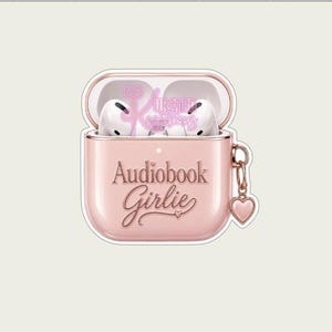 Może przedstawiać: Różowe etui na AirPods z napisem "Audiobook Girlie" w ozdobnej czcionce. Etui jest otwarte, ukazując białe słuchawki AirPods w środku. Z boku wisi mały urok w kształcie serca. Etui ma wykończenie w kolorze różowego złota.