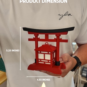 May include: A red miniature Japanese Torii gate with a lantern, measuring 5.25 inches tall and 4.55 inches wide. Includes an LED tea light. The product is part of the Miniature Series.