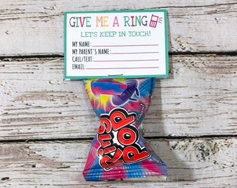 Pode incluir: Um embrulho de doce Ring Pop colorido com uma etiqueta anexada que diz "Dê-me um toque" e inclui um espaço para escrever as informações de contato.