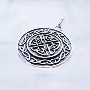May include: Silver Celtic knot pendant with a circular design. The knot is intricate and detailed, and the pendant has a loop at the top for attaching to a chain.