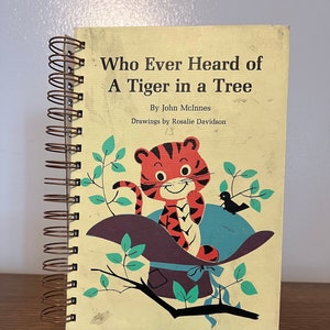 May include: A vintage children's book titled "Who Ever Heard of A Tiger in a Tree" by John McInnes with illustrations by Rosalie Davidson. The cover features a cartoon tiger sitting in a hat on a tree branch.
