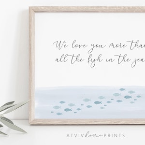 Könnte beinhalten: Ein gerahmter Druck mit einem hellblauen Aquarellhintergrund und dem Text "We love you more than all the fish in the sea".