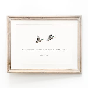 Puede incluir: Una impresión enmarcada con dos patos volando. Los patos están representados en tonos marrones, verdes y negros. La impresión incluye el texto "EVERY GOOD AND PERFECT GIFT IS FROM ABOVE" y "JAMES 1:17". El marco es de color marrón claro.