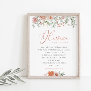 Puede incluir: Una impresi&oacute;n enmarcada con el nombre Olivia Grace Watson en texto rosa, rodeado de ilustraciones florales en acuarela. El texto dice: You are a child of God. You are wonderfully made, dearly loved, and precious in His sight. Before God made you He knew you. There is no one else like you! Baptized March 28, 2022.