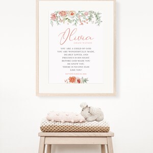 Puede incluir: Un cuadro enmarcado con detalles florales en acuarela en tonos rosa y verde, con el nombre Olivia Grace Watson y el texto religioso: You are a child of God. You are wonderfully made, dearly loved, and precious in His sight. Before God made you He knew you. There is no one else like you! Baptized March 28, 2022.