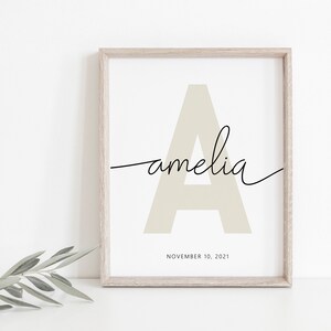 May include: A beige letter A with the name "amelia" written in cursive script below it. The date "NOVEMBER 10, 2021" is printed below the name.