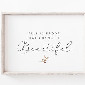 May include: A rectangular light wood frame containing a white print with the black text FALL IS PROOF THAT CHANGE IS Beautiful. Below the text is a small, simple illustration of a brown botanical sprig with several small leaves.
