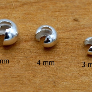 May include: Three silver-toned metal bead caps, 5 mm, 4 mm, and 3 mm in size. The caps are designed to be used as end caps for necklaces or bracelets.