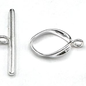 May include: Silver toggle clasp with a straight bar and a twisted oval loop. The clasp is used for necklaces, bracelets, and other jewellery.