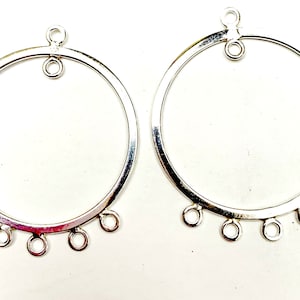 May include: Two silver circular earring blanks with five jump rings on each blank. The blanks are ready to be customized with beads, charms, or other jewelry findings.