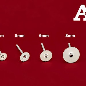Könnte beinhalten: Sechs silberfarbene Ohrstecker mit flachen, runden Plättchen, angeordnet in aufsteigender Größe von 3mm bis 10mm. Der Text A-Z steht in der oberen rechten Ecke, wobei jeder Ohrstecker mit seinem Durchmesser in Millimetern beschriftet ist.