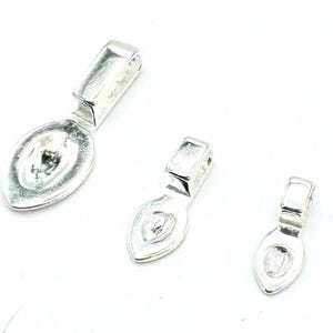 May include: Three silver-toned pendant bails in different sizes. The bails are shaped like a teardrop with a flat, oval-shaped top.