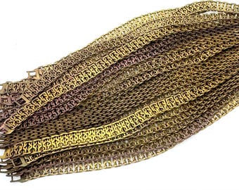 Könnte beinhalten: Ein Stapel goldfarbener Metallkettenglieder. Die Ketten sind ineinander verschlungen und haben ein gewebtes Muster.