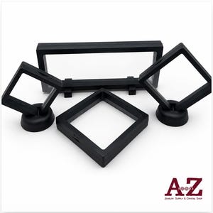 Op de afbeelding: Een set van vier zwarte zwevende displayframes met doorzichtige membranen. De set bevat één groot rechthoekig frame, twee vierkante frames op ronde voetjes en één platliggend vierkant frame. Het logo A-Z Jewelry Supply & Crystal Shop is zichtbaar.