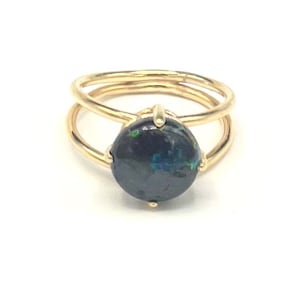 May include: A gold ring with a black opal gemstone set in a double band design.