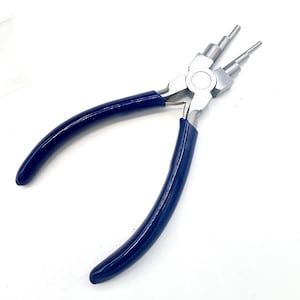 May include: Bail making pliers featuring a silver-toned metal head with three distinct stepped cylindrical tiers on each jaw for creating loops of varying sizes, paired with smooth, dark blue rubberized ergonomic handles for a secure grip.
