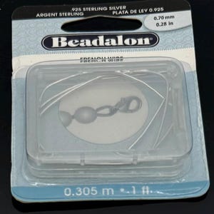 May include: A package of Beadalon French wire, 0.70 mm (0.28 in) diameter, made of 925 sterling silver. The package includes a clear plastic container with the wire and a clasp. The packaging also indicates the wire is 0.305 m (1 ft) in length.