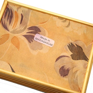 May include: A wooden tray with a floral pattern and a label that reads "Made in MADAGASCAR".