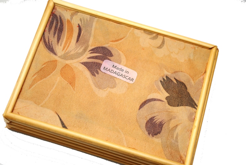 May include: A wooden tray with a floral pattern and a label that reads "Made in MADAGASCAR".