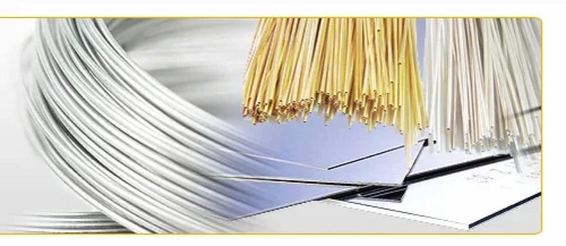 Puede incluir: Primer plano de tres carretes de alambre. El primer carrete es plateado, el segundo es dorado y el tercero es blanco. Los carretes est&aacute;n dispuestos en fila, con el carrete plateado a la izquierda, el carrete dorado en el centro y el carrete blanco a la derecha.