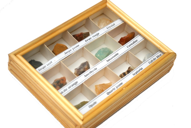 May include: A wooden box with a glass top containing a collection of 12 different types of rocks and minerals. Each rock is labeled with its name in French.