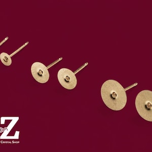 May include: Three pairs of gold-toned metal earring studs with flat circular pads for attaching components. The studs are arranged in increasing size from left to right. The text A-Z Jewelry Supply & Crystal Shop is visible in the corner.