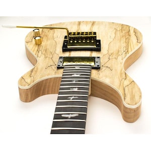 May include: A light wood electric guitar with a black fretboard and gold hardware. The guitar has a unique wood grain pattern and a single pickup.