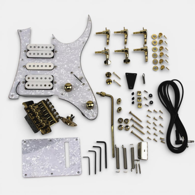 A guitar kit featuring a white pickguard, gold hardware, and a black cable. The kit includes a bridge, pickups, knobs, tuning pegs, screws, and other hardware for Ibanez Jem Guitar build. By The Guitar Fabrik