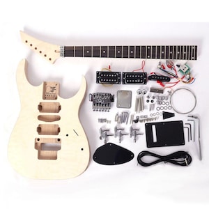 Pode incluir: Um kit de guitarra elétrica inacabado com um corpo de madeira de cor clara com três cavidades para captadores e um braço a condizer com uma escala escura. Inclui captadores humbucker pretos, ponte tremolo cromada, tarraxas, cablagem, parafusos e um cabo preto.