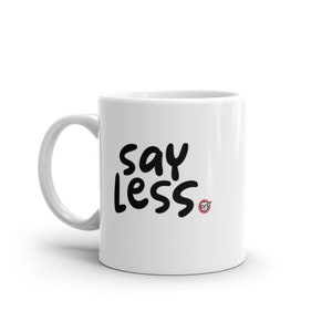 May include: White ceramic mug with black text that reads "say less" and a small red circle with a cartoon face in the bottom right corner.