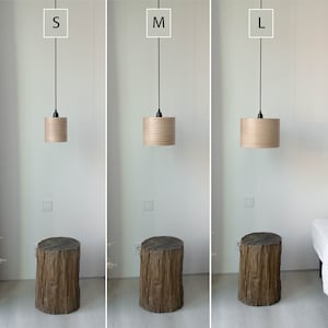 May include: Three wooden pendant lights in different sizes, labeled S, M, and L. The lights are hanging from black cords and have a natural wood finish.