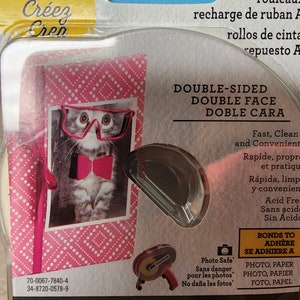 May include: Scotch Create double-sided tape refill. The package features a pink and white polka-dot design with a photo of a cat wearing glasses and a bow tie. The tape is 0.25 inches wide and 36 yards long, and is photo safe.